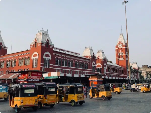 Chennai Central Railway Station with its distinct architecture and yellow auto-rickshaws parked in the foreground.